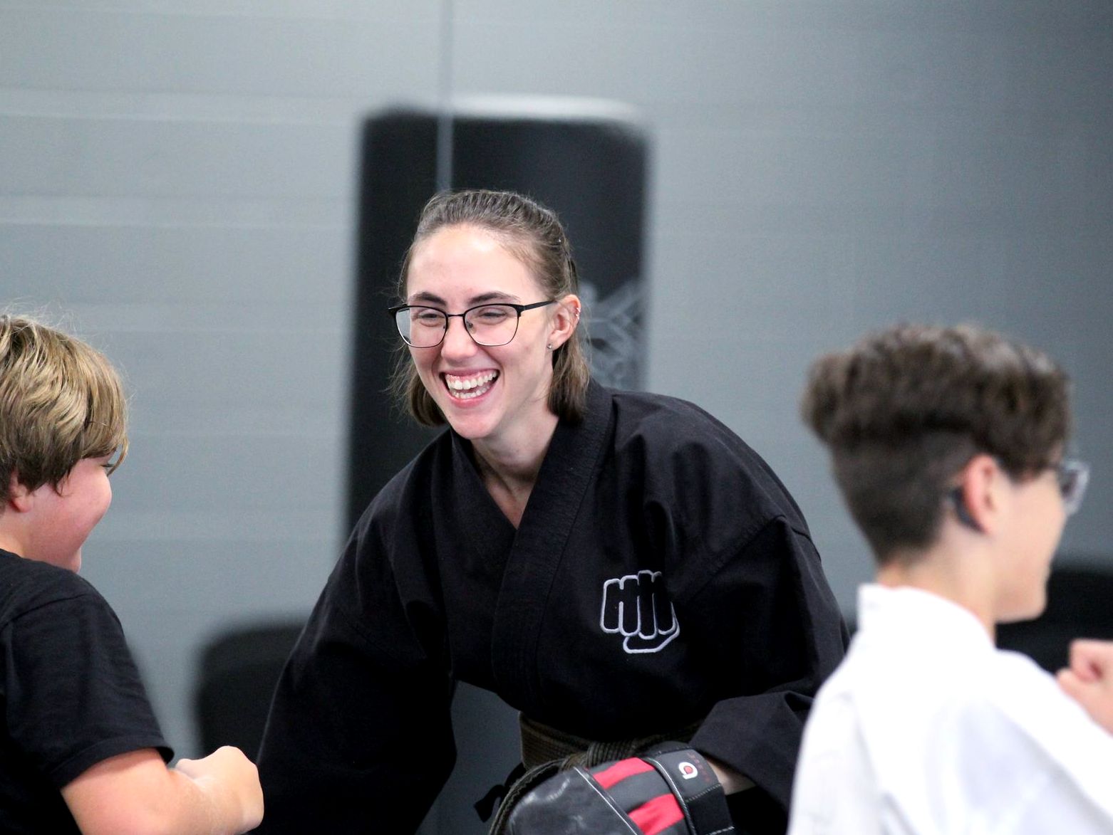 An instructor laughing with young students during class